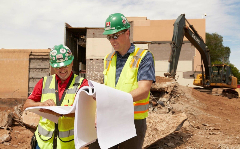 Jaynes employees build a wooden frame atop a concrete foundation, building from the ground up.
